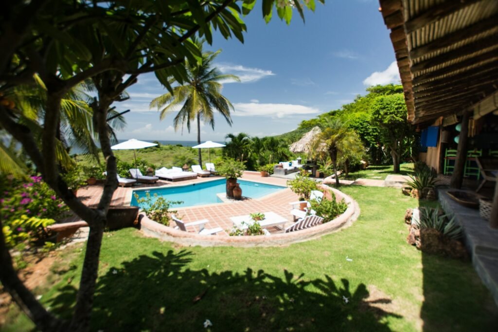 Beach house with pool. Rustic furniture. Sun loungers, umbrellas, wooden tables. Caribbean colors.